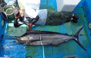 カジキと横になっている釣り人
