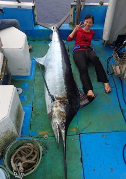 カジキを釣り上げピースサインの女性