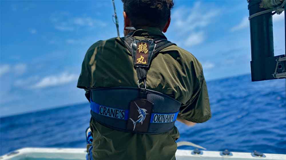 沖縄の海でカジキを釣っている男性の後ろ姿