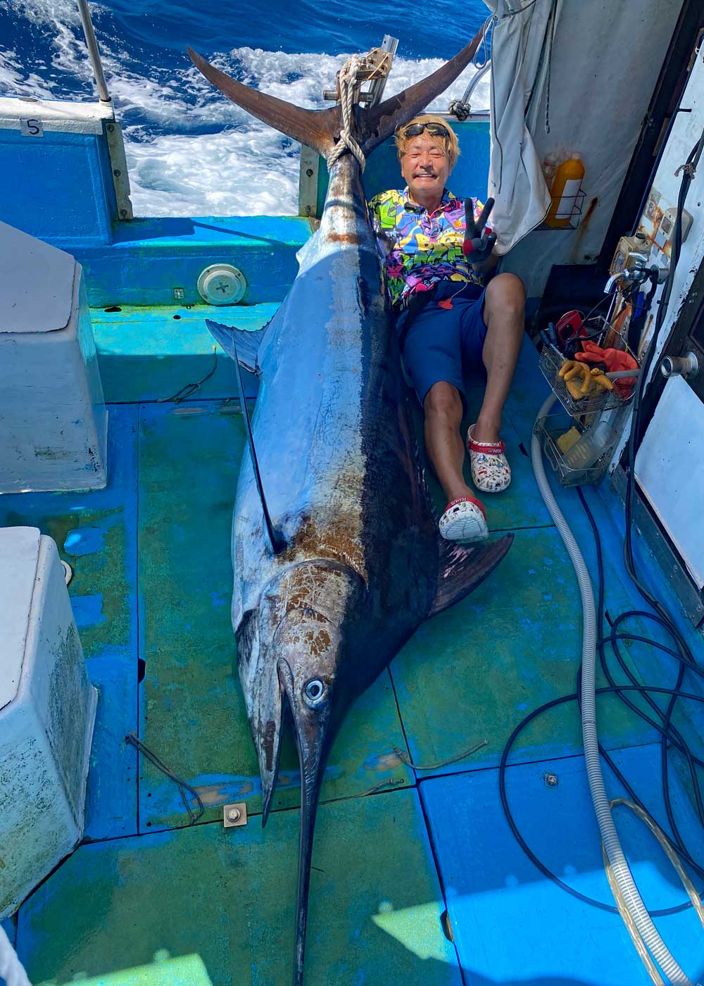 釣り上げたカジキと釣り師の男性