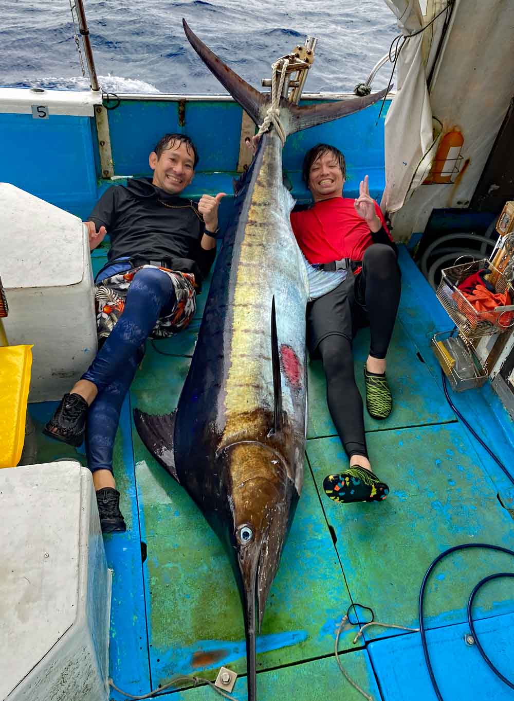 トローリングで釣り上げたカジキと二人の男