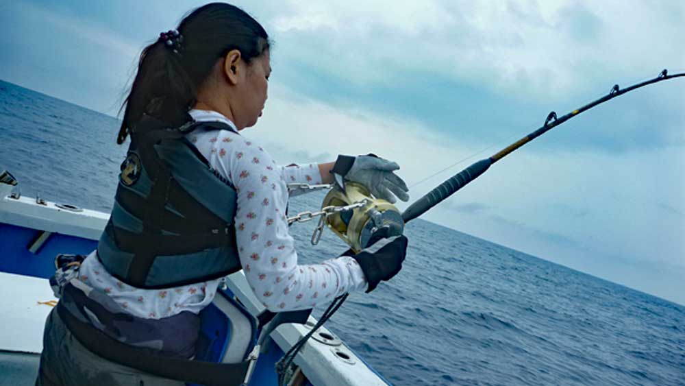 沖縄のトローリングでカジキ釣りをしている女性