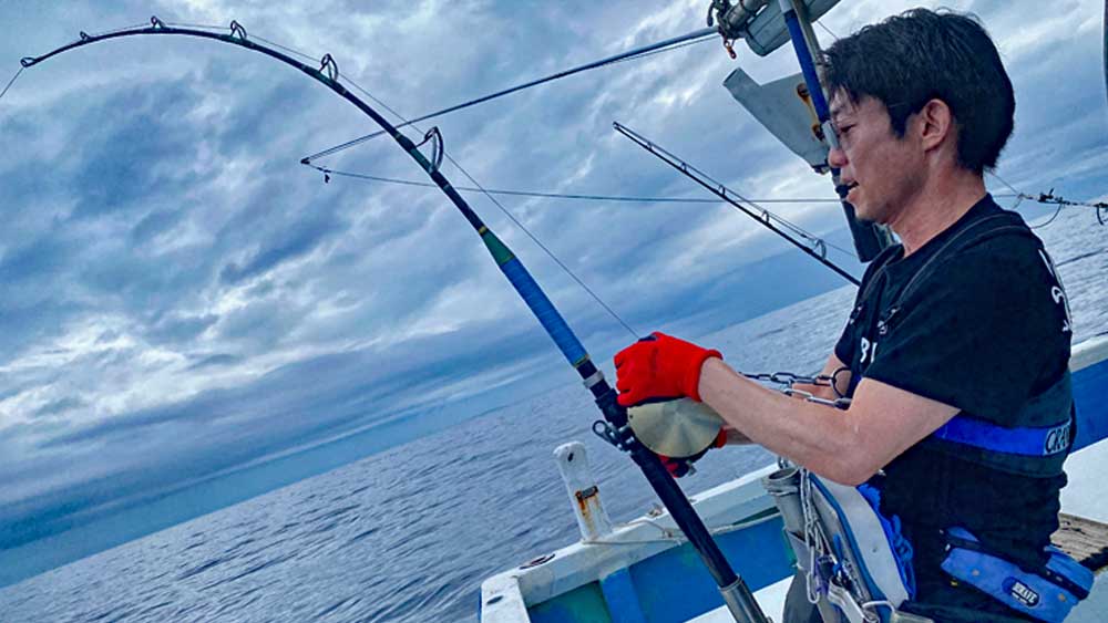 沖縄の海でカジキ釣りをしている男性