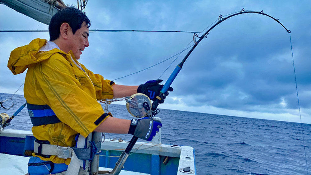 沖縄の海でカジキ釣りをしている男性