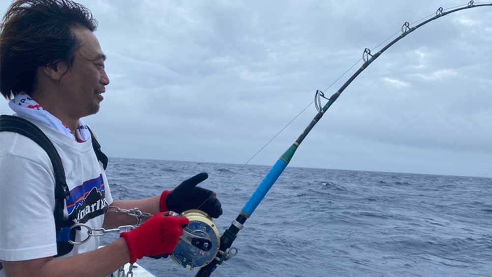 沖縄のトローリングでキハダマグロを釣っている男