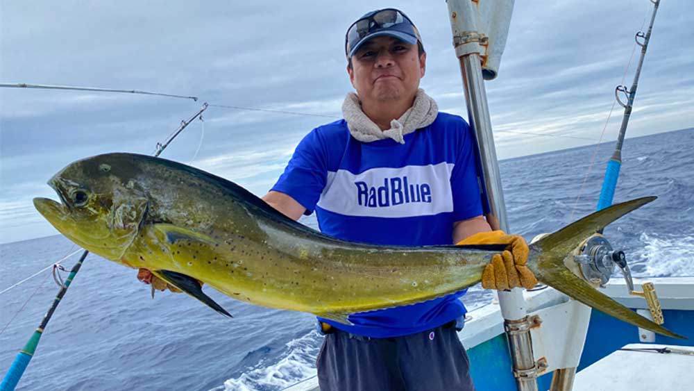 沖縄のトローリングで釣り上げたシイラと男性