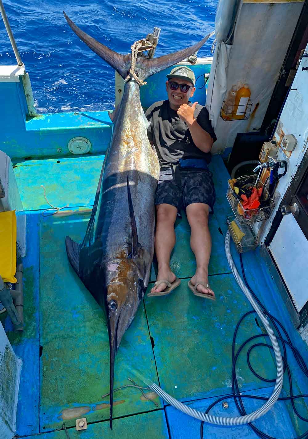 トローリングで釣り上げたカジキと男性