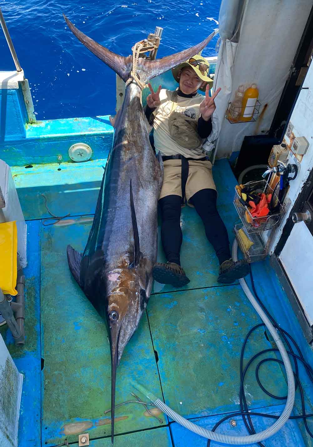 釣り上げたカジキと男