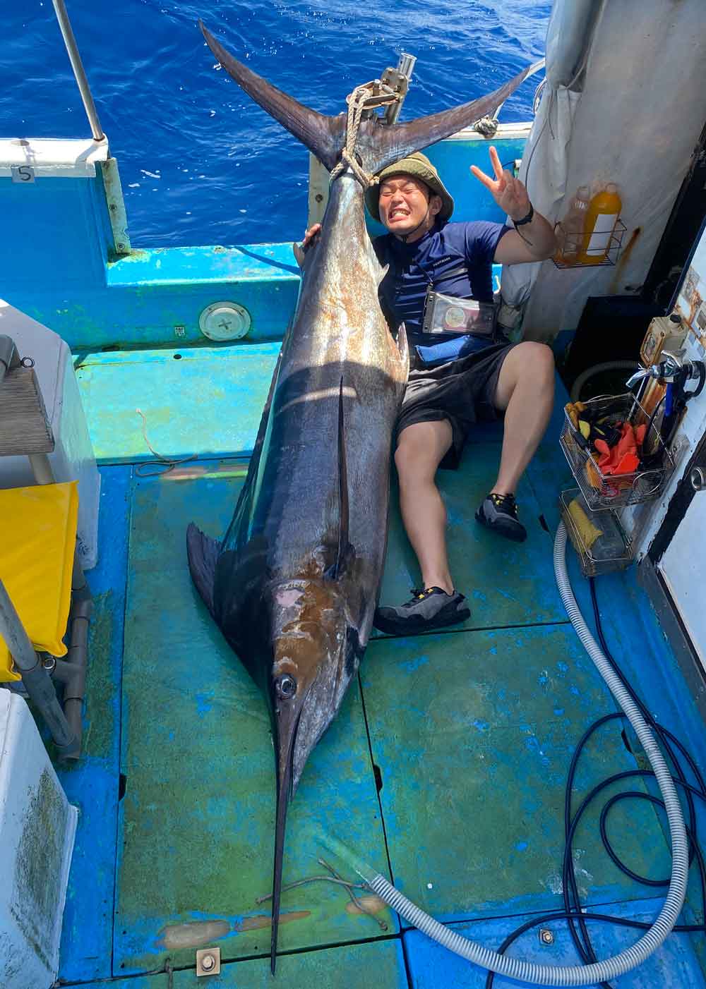 カジキを釣り上げ喜ぶ男性