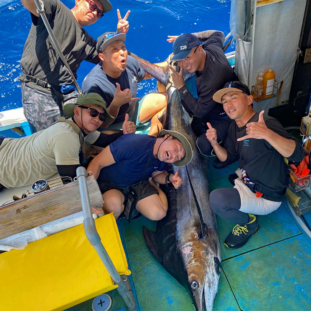 カジキを釣り喜ぶ6人の男性