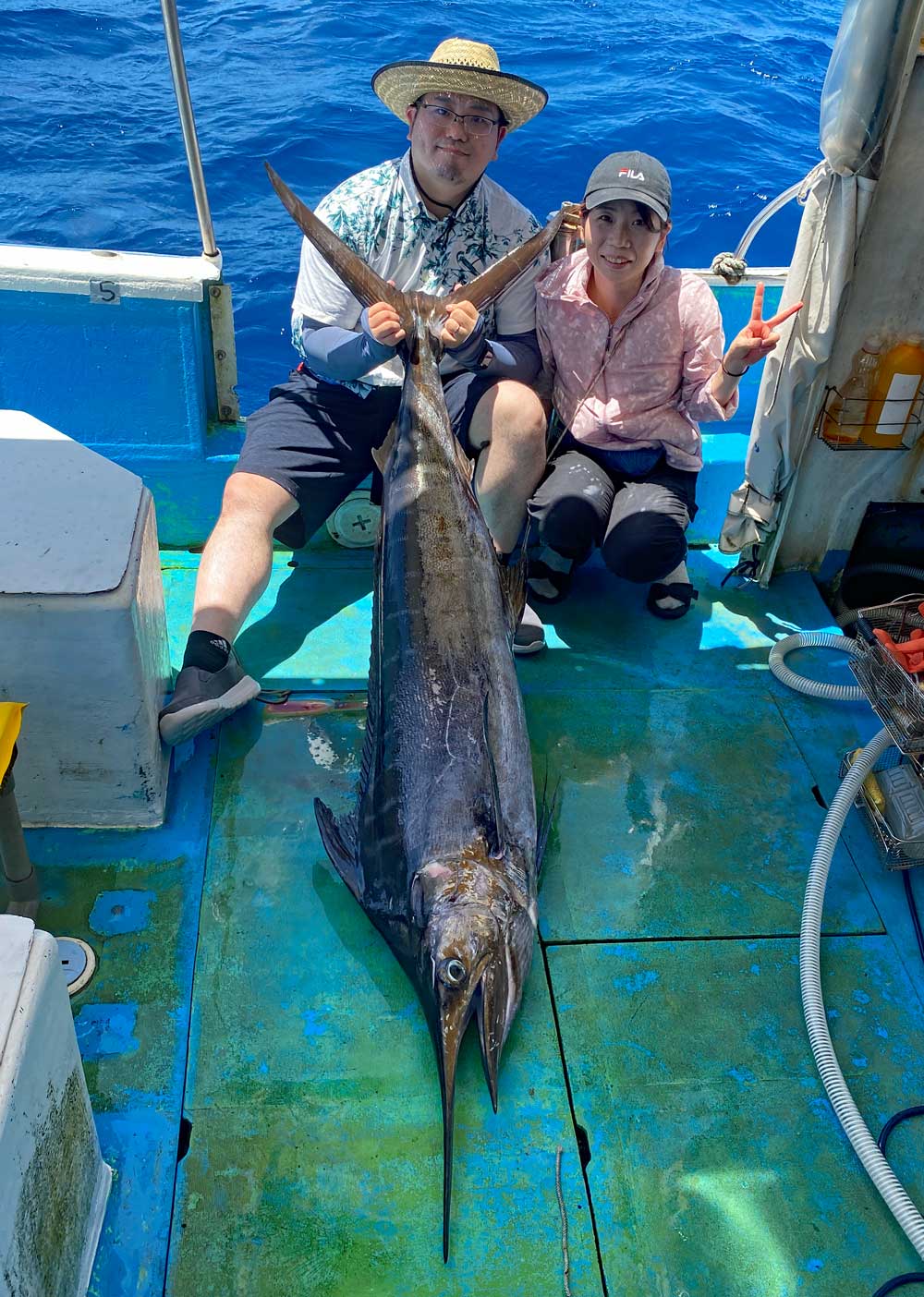 釣り上げたカジキをと長崎県から沖縄へ釣りに来た夫婦