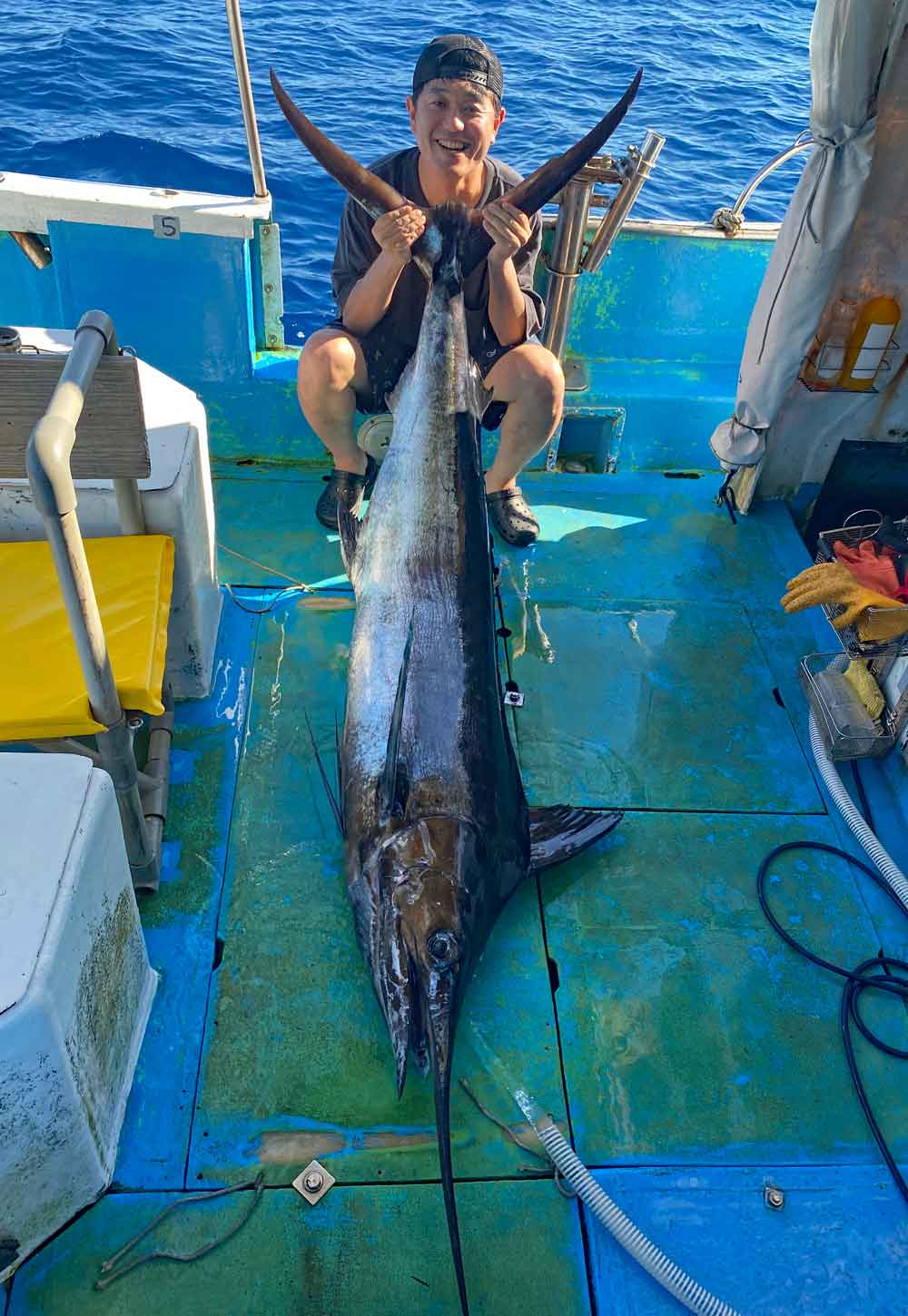 沖縄の社員旅行でカジキを釣った男性