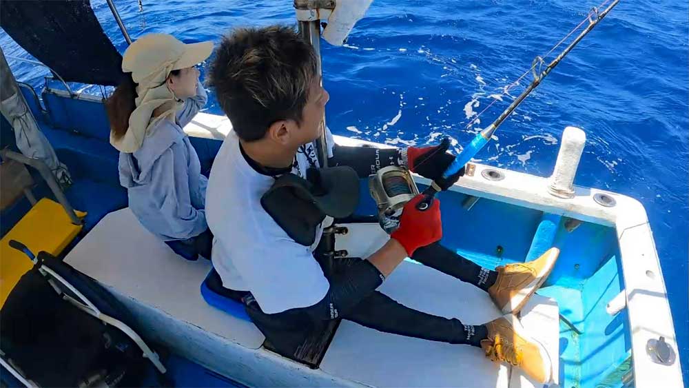 沖縄でカジキを釣っている車いすアングラーと隣で見守る妻