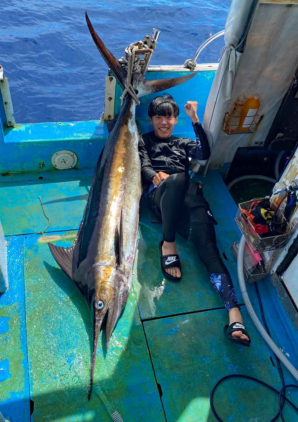 ブルーマーリンを釣り上げ喜ぶ愛媛県から沖縄にカジキを釣りに来た高校生