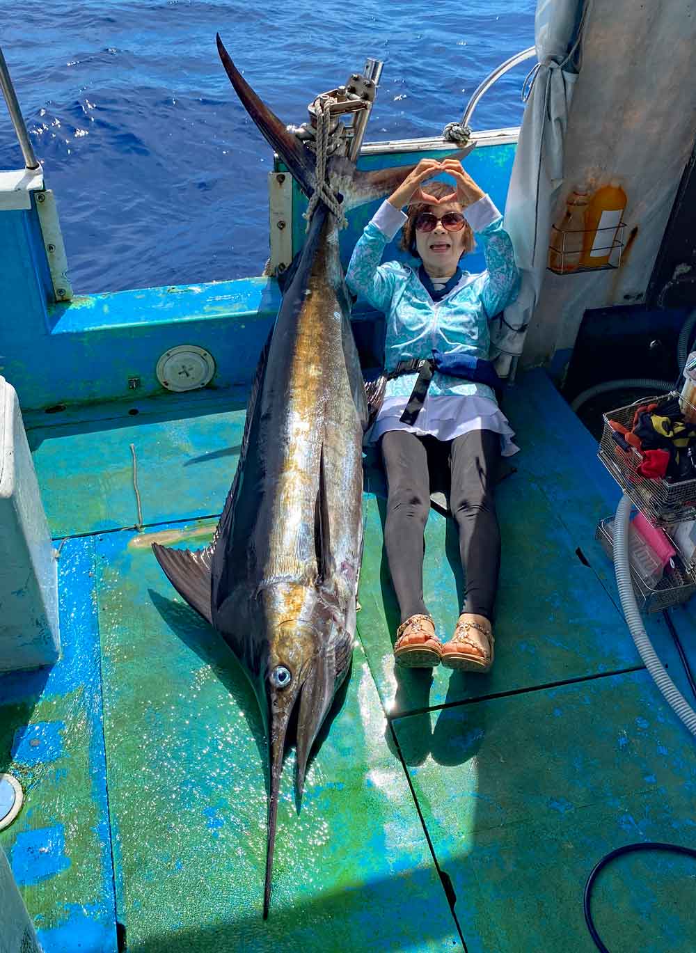 カジキを釣り上げハートマークの祖母