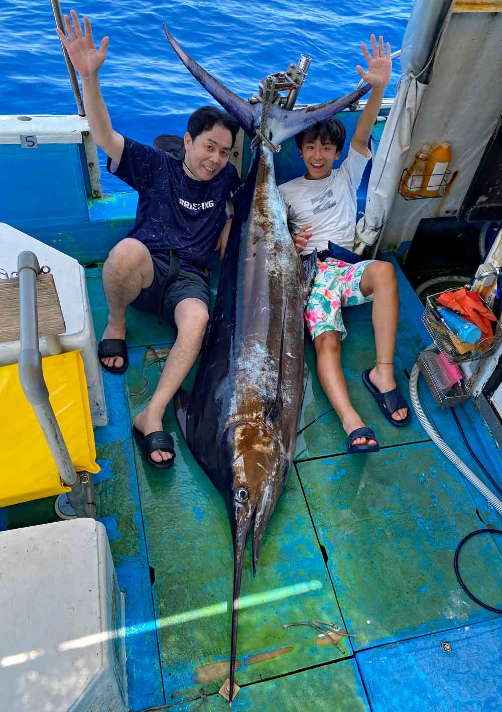 沖縄でカジキを釣り上げ喜ぶ愛知県の男性と中学生の息子