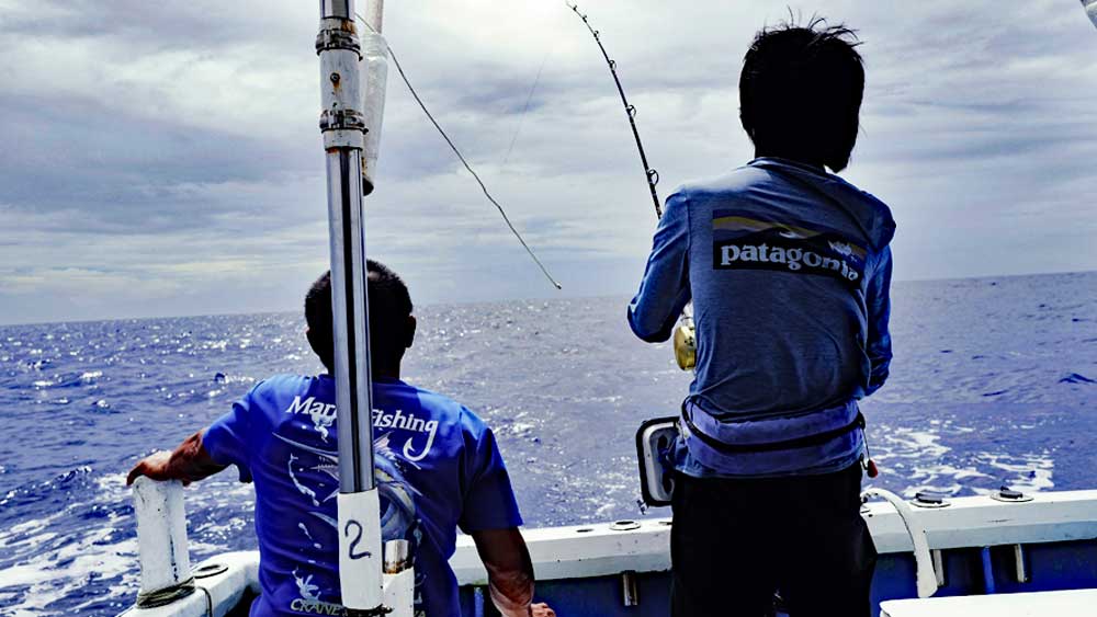 沖縄のトローリングでシイラを釣っている中国の男性