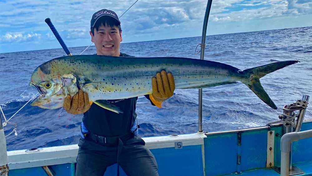 鶴丸のトローリングでシイラを釣り上げた男性