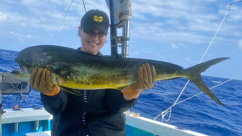 沖縄のトローリングでシイラを釣り上げた女性