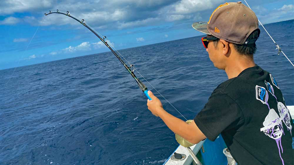 トローリングで大物を釣っている男性