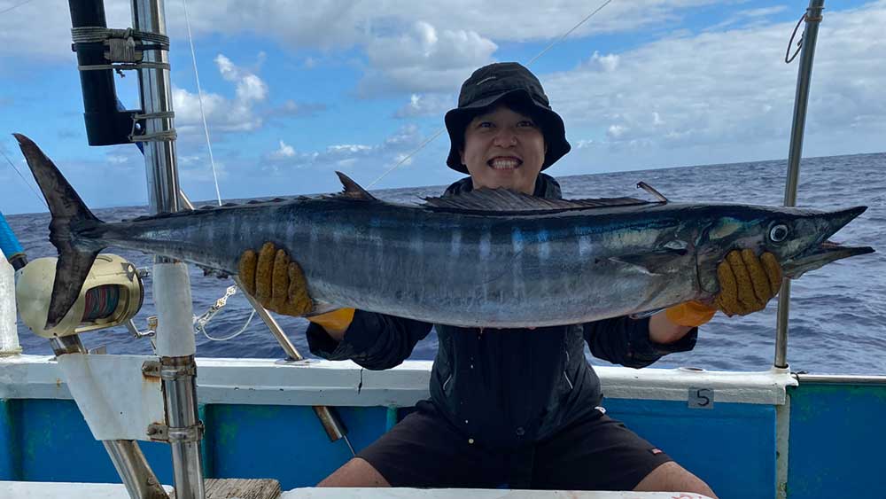 鶴丸のトローリングでカマスサワラを釣り上げた帽子の男性