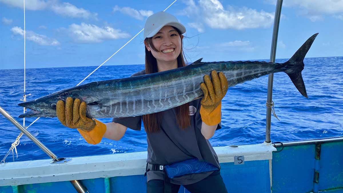 沖縄のトローリングでカマスサワラを釣り上げ喜ぶ女性