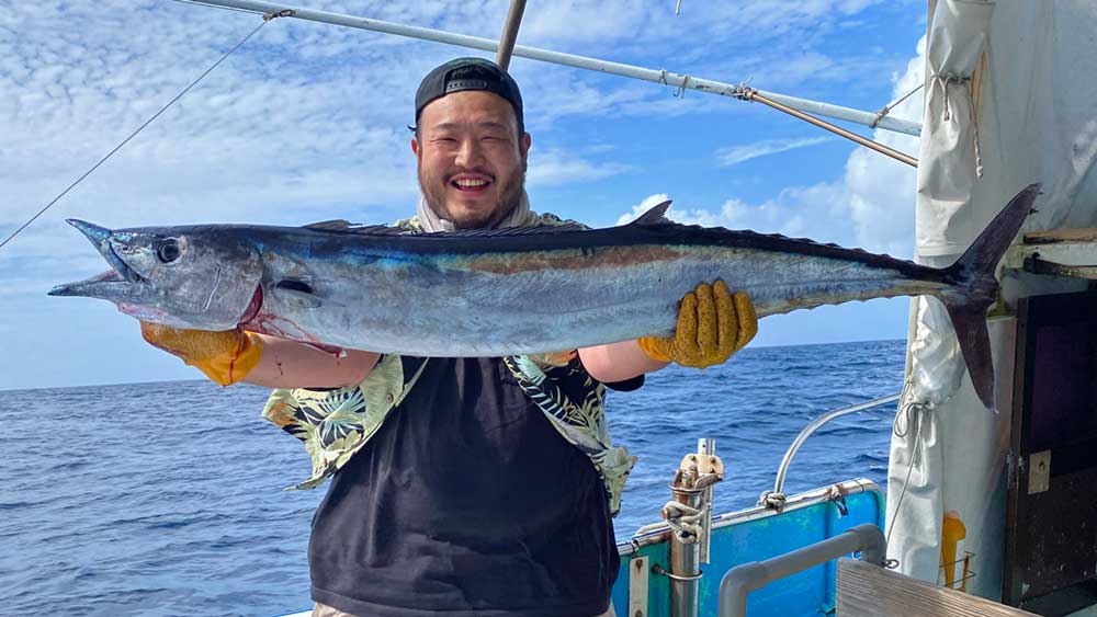 トローリングでカマスサワラを釣り上げ喜ぶ男性