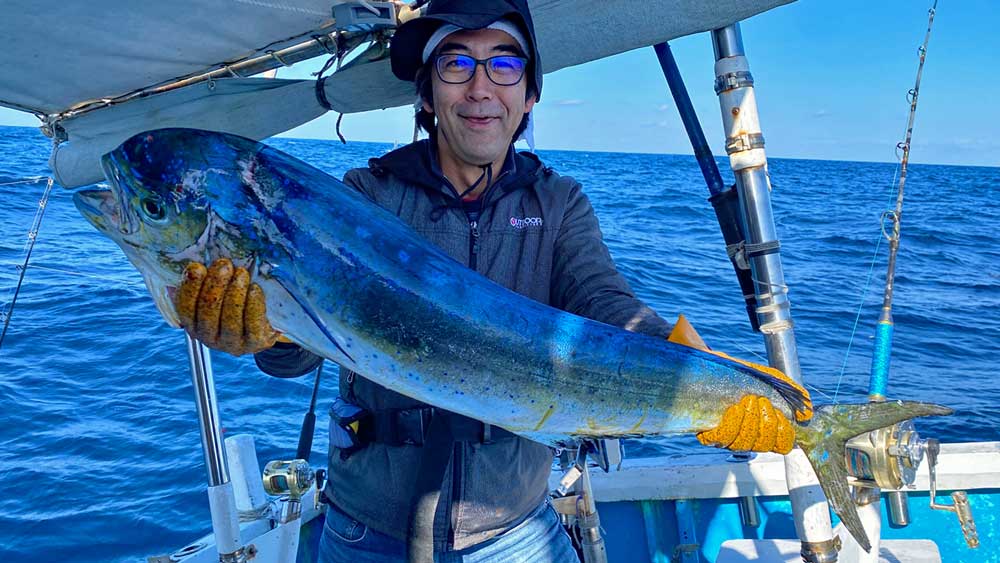 シイラを釣り上げ喜ぶ男性