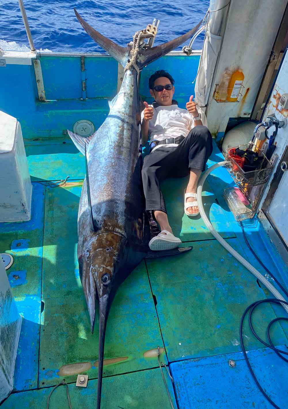 カジキを釣り上げ喜ぶ男性