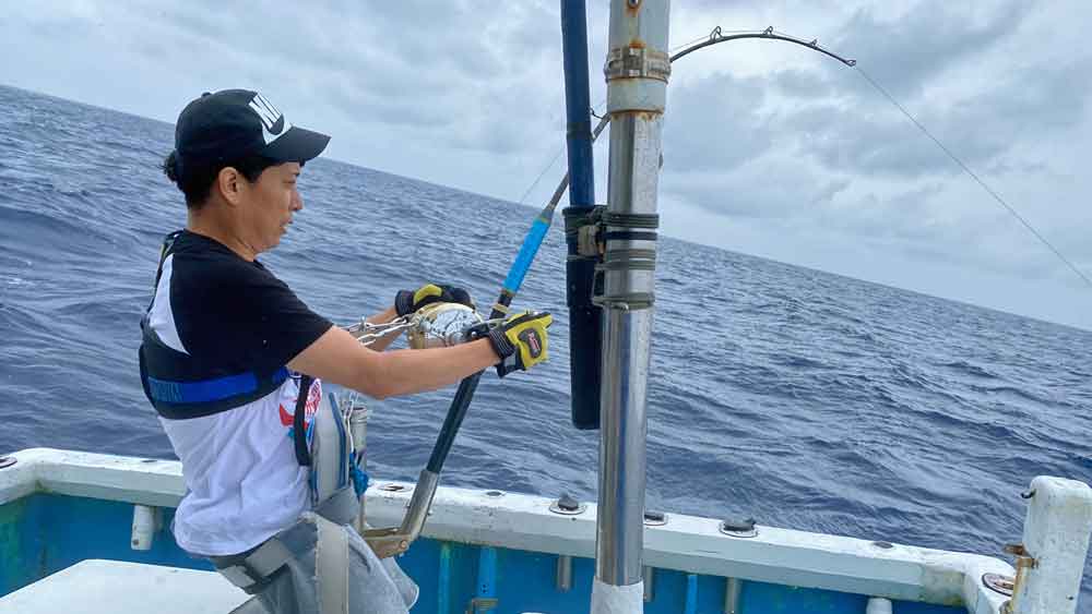 沖縄でカジキ釣りをしている男