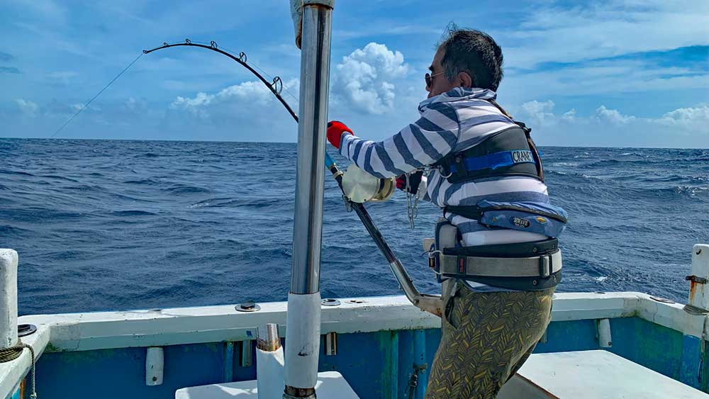 沖縄のトローリングでカジキ釣りをしている男