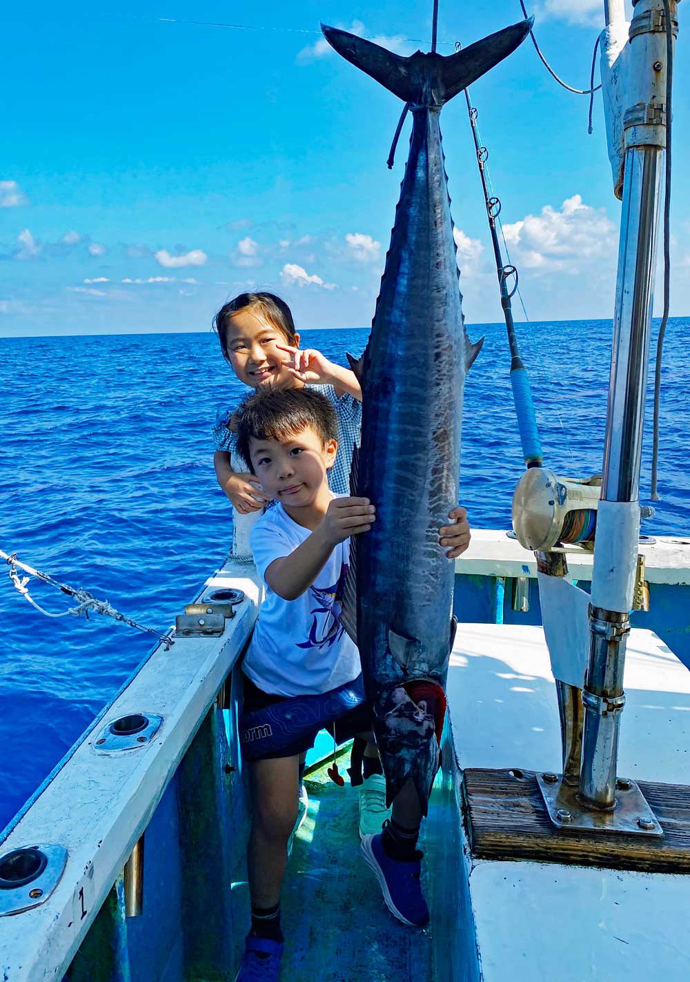 トローリングで釣り上げたカマスサワラと少年少女