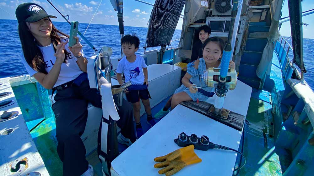カマスサワラを釣っている少女と見守る家族