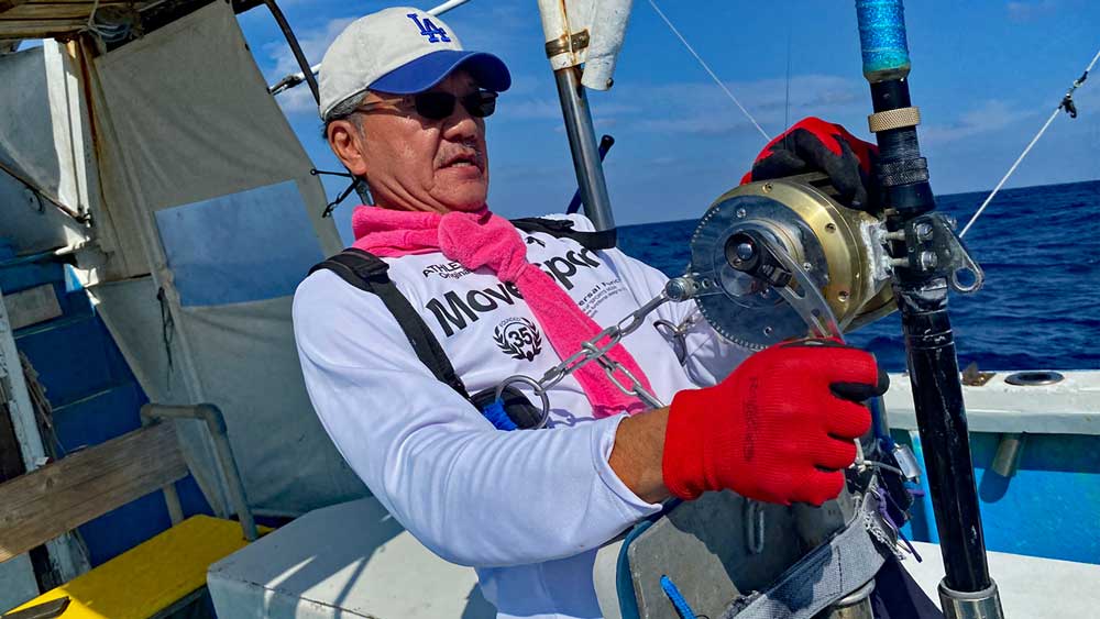 沖縄の海でカジキ釣りをしている男性