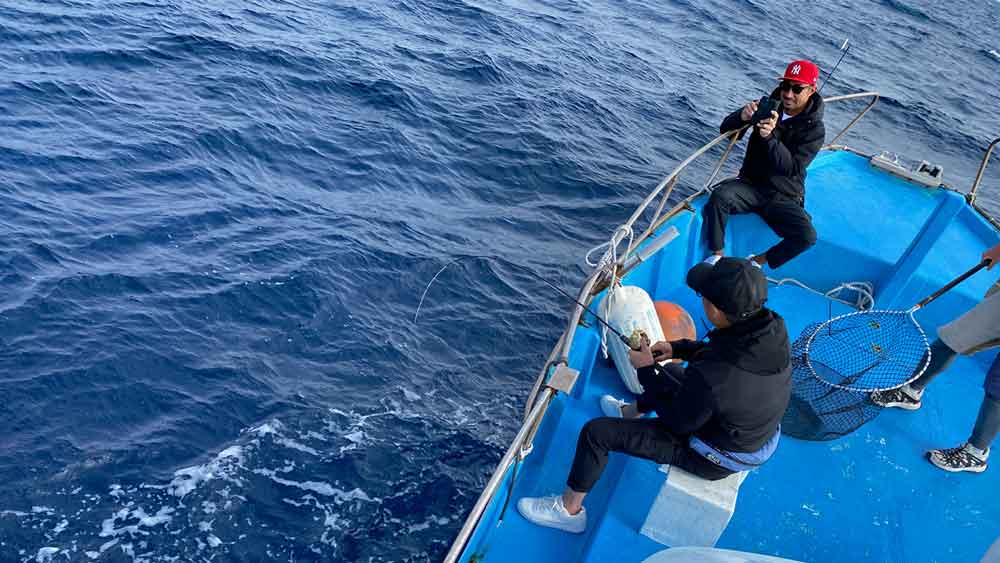 タイラバで大物がヒットしている男性と撮影している男