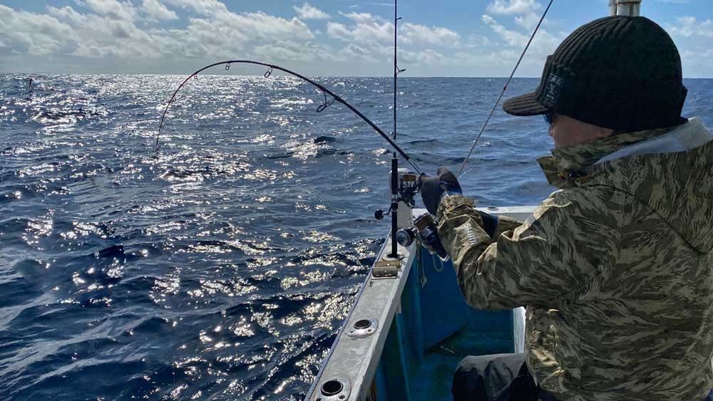 沖縄のジギングでカンパチ釣りをしている男性