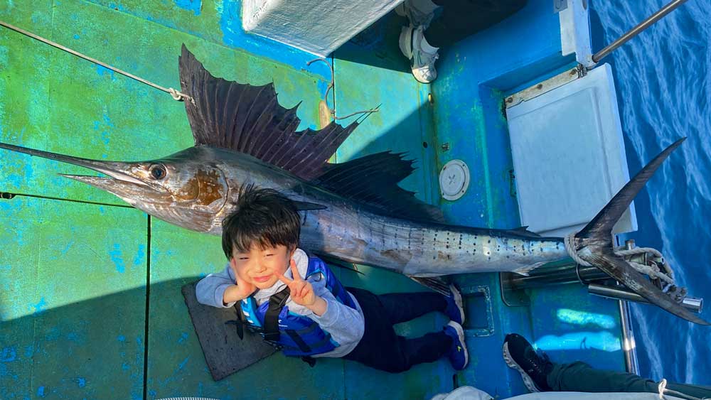 釣り上げたバショウカジキと5才の少年