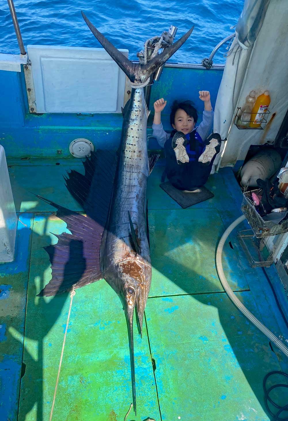 バショウカジキを釣り上げガッツポーズの5才の少年