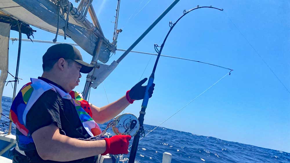 沖縄のトローリングでカジキ釣りをしている男