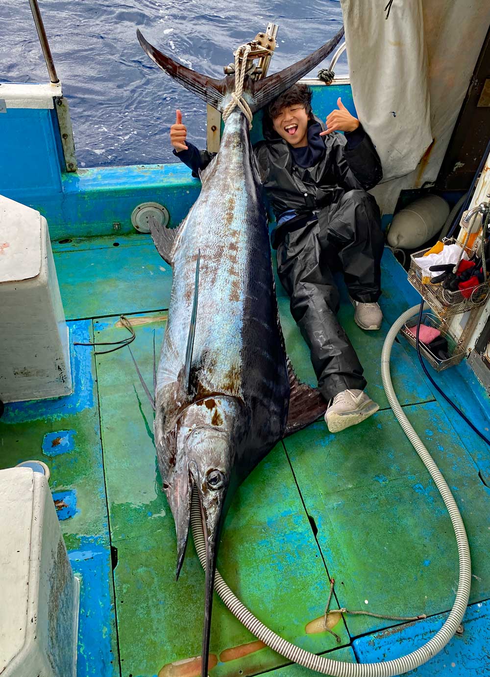 カジキを釣り上げ喜ぶ高校生
