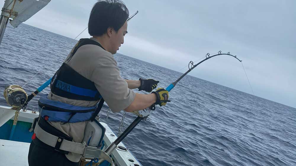 沖縄のトローリングでブルーマーリンを釣っている男性