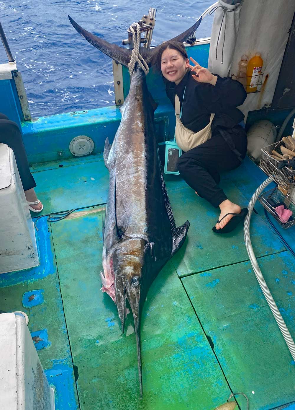 釣り上げたカジキと笑顔の女性