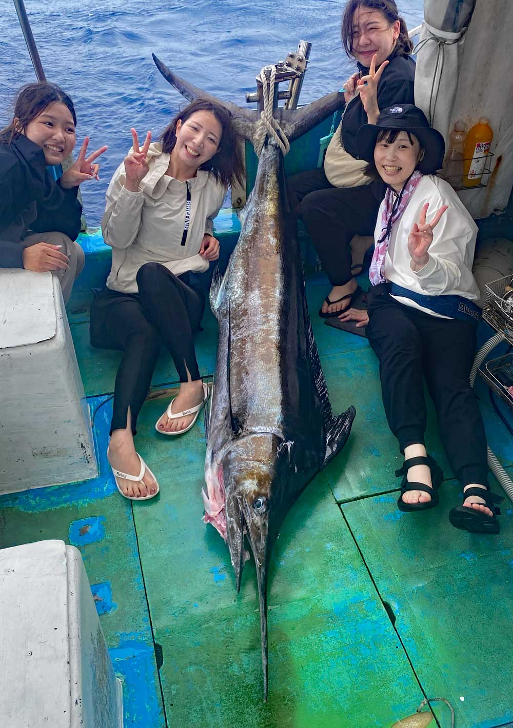 沖縄のトローリングでカジキを釣り上げた4人の女性