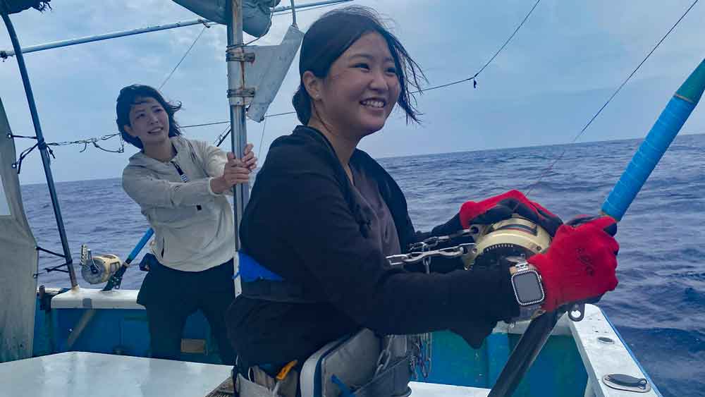 沖縄でカジキ釣りをしている笑顔の女性