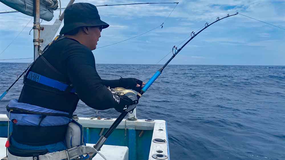 沖縄でカジキ釣りをしている男性