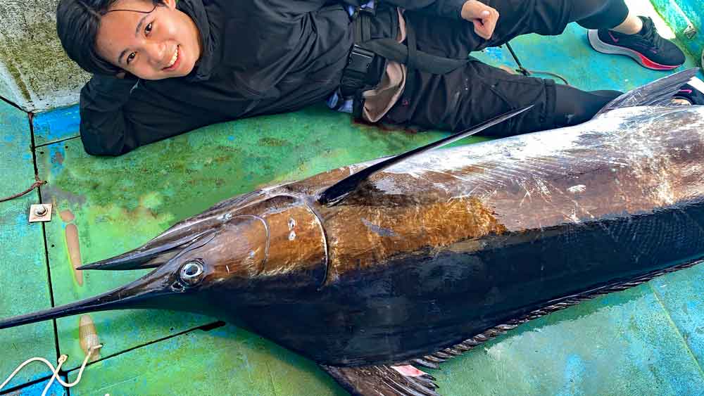 釣り上げたカジキの横になっている四人兄弟の末っ子