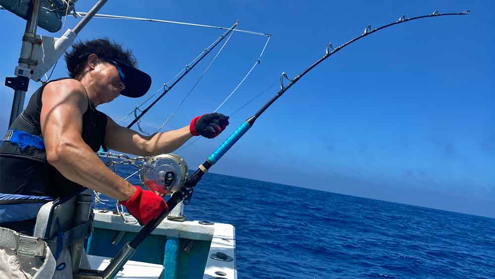 沖縄のトローリングでカジキ釣りをしている男性