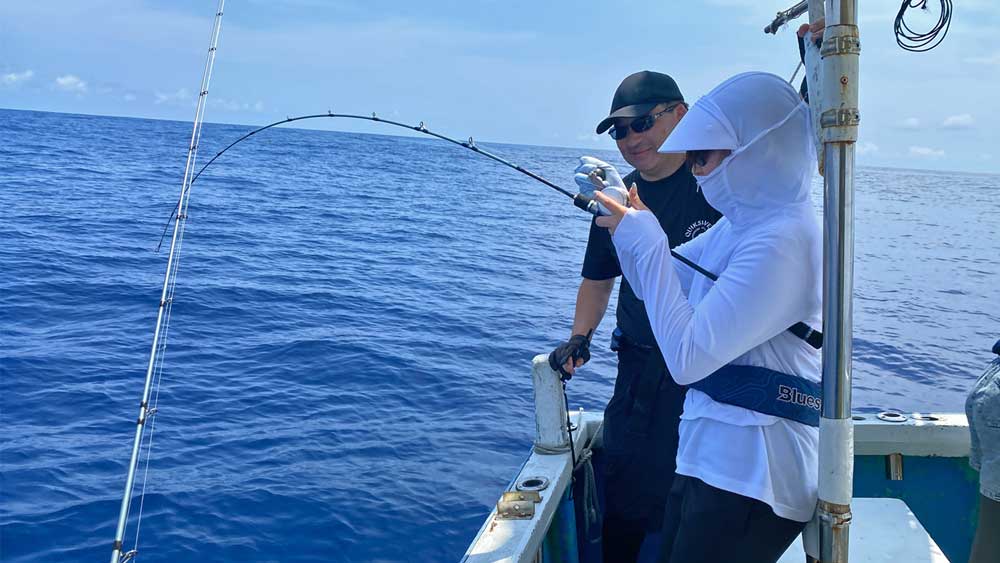 沖縄タイラバでアオチビキ釣りをしている娘と横で見守る父