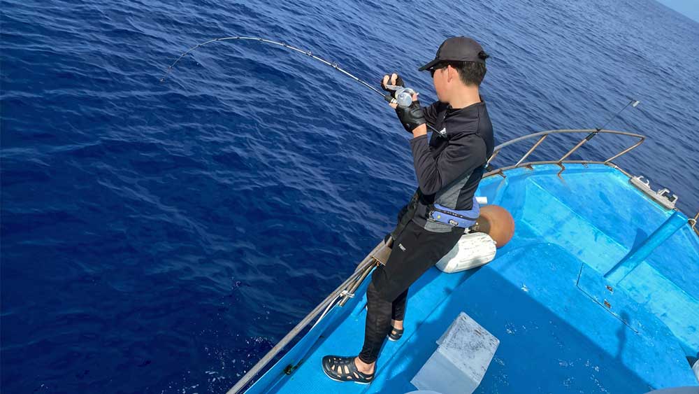 沖縄のジギングでカンパチ釣りをしている男性