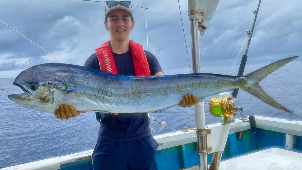シイラを釣り上げた若い男性